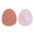 Two silicone sponges, one pink and one purple, on a white background.