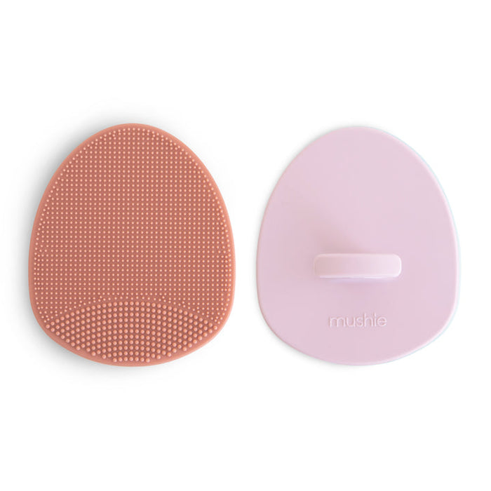 Two silicone sponges, one pink and one purple, on a white background.