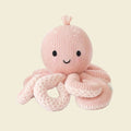 Knitted pink octopus toy with a smiling face