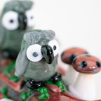 Two glass decorative owls on glass spoon pipe
