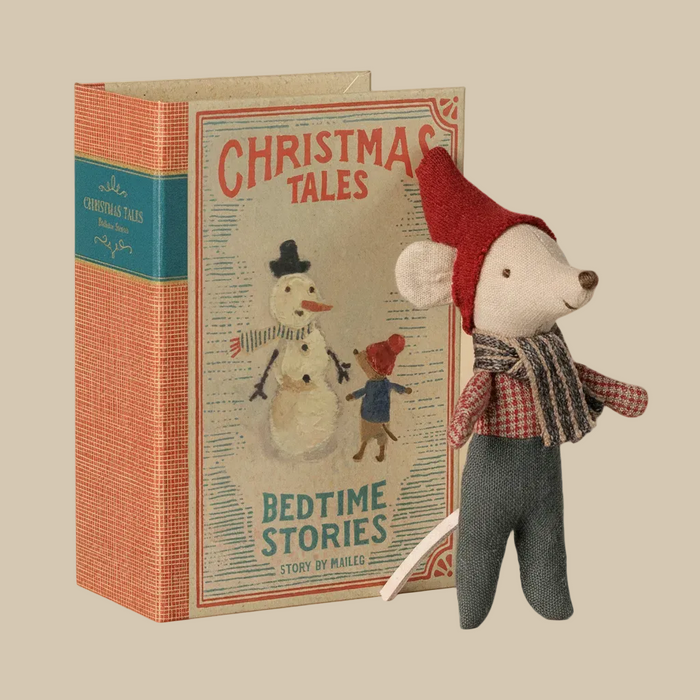 A plush mouse doll dressed in a red hat and scarf, standing next to a vintage-style children's book titled "Christmas Tales: Bedtime Stories" on a plain white background.