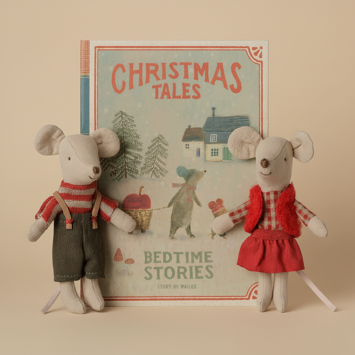 A children's book titled 'Christmas Tales: Bedtime Stories' displayed upright, with two small plush mouse toys in holiday clothing posed in front on both sides against a plain white background.