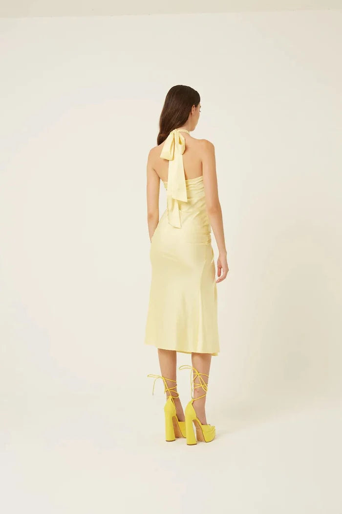 Back view of butter yellow satin midi dress with halter tie neckline